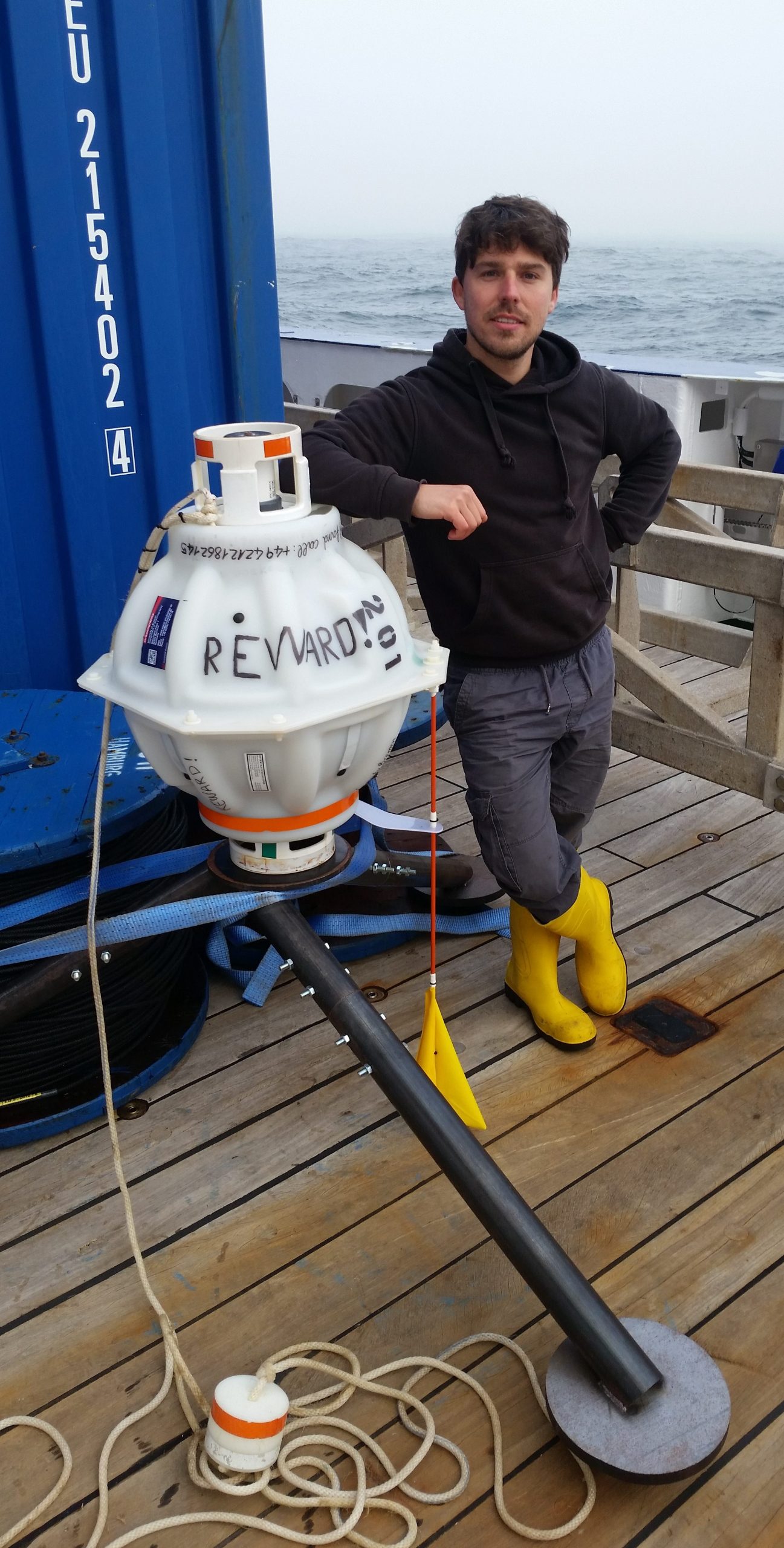 Arne auf einem Schiff, der sich an ein Forschungsinstrument anlehnt. 